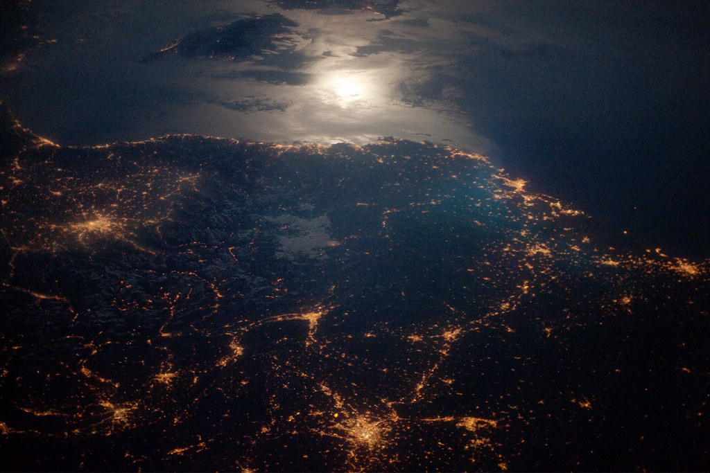 France under clouds with city lights connected.